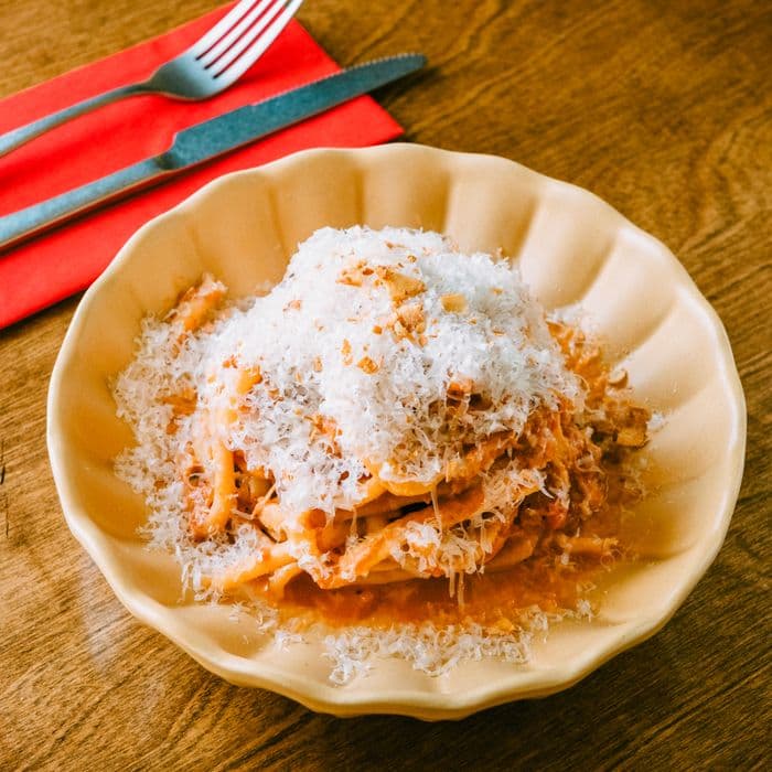 Grated parmesan piled on a bowl of spaghetti
